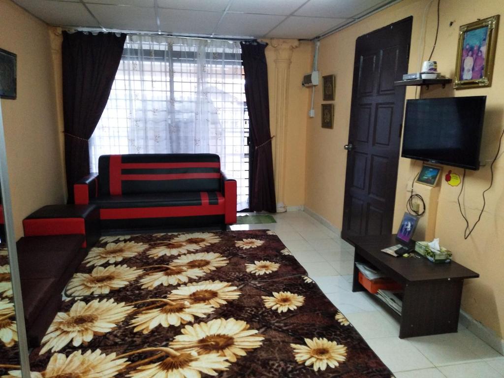 sala de estar con sofá y TV en De La Homestay en Alor Setar