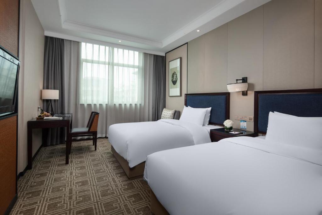 Postel nebo postele na pokoji v ubytování Yiwu Kasion Purey Hotel