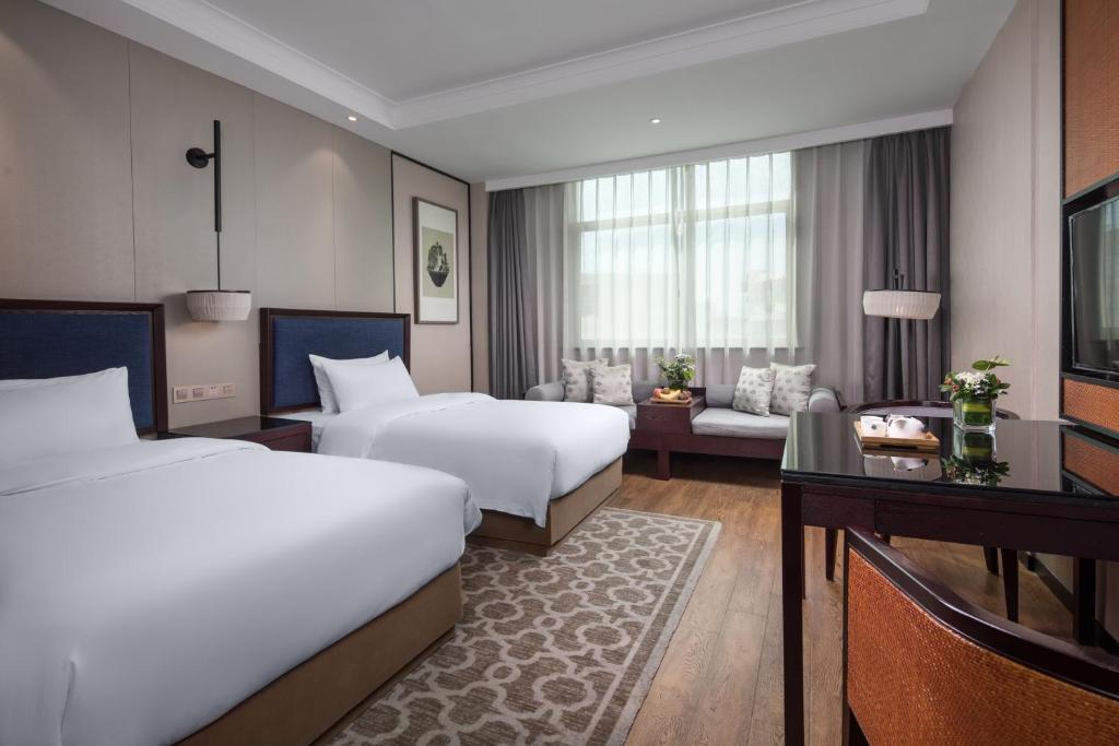 Postel nebo postele na pokoji v ubytování Yiwu Kasion Purey Hotel