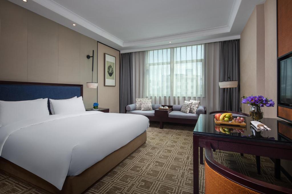 Postel nebo postele na pokoji v ubytování Yiwu Kasion Purey Hotel
