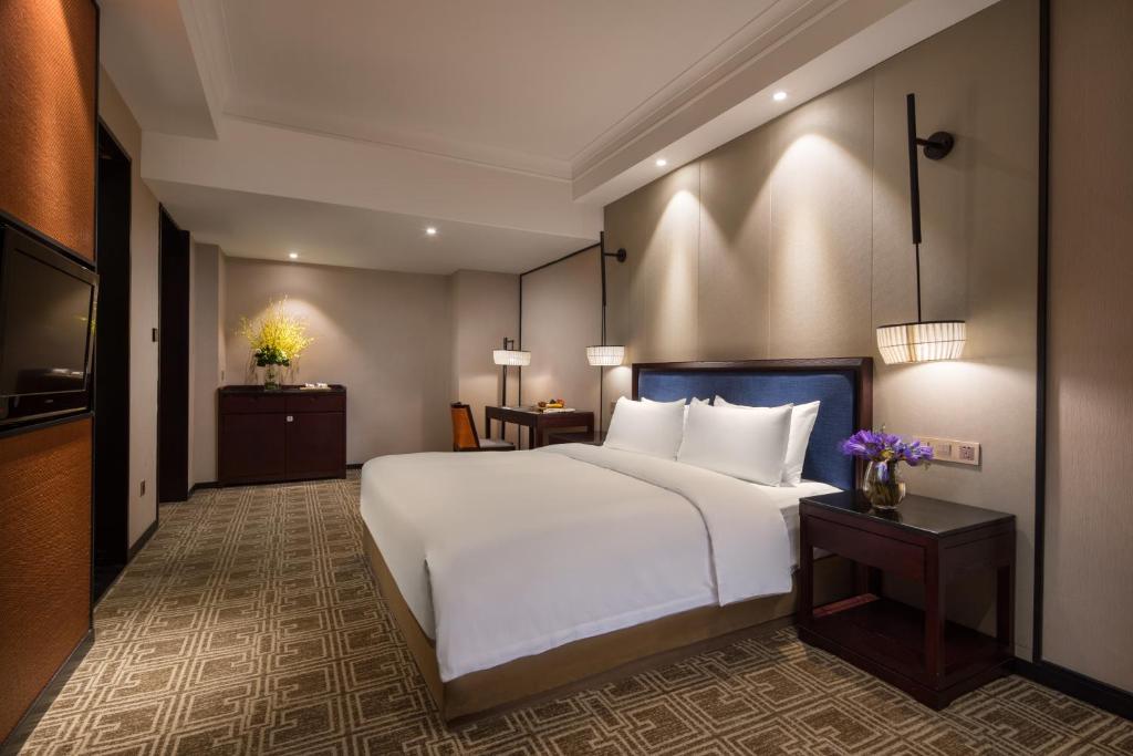 Postel nebo postele na pokoji v ubytování Yiwu Kasion Purey Hotel
