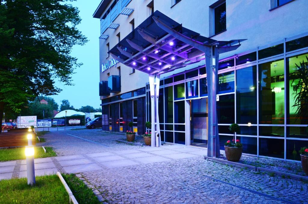 un edificio con luces púrpuras en el lateral. en Apart Chopin, en Pruszcz Gdański