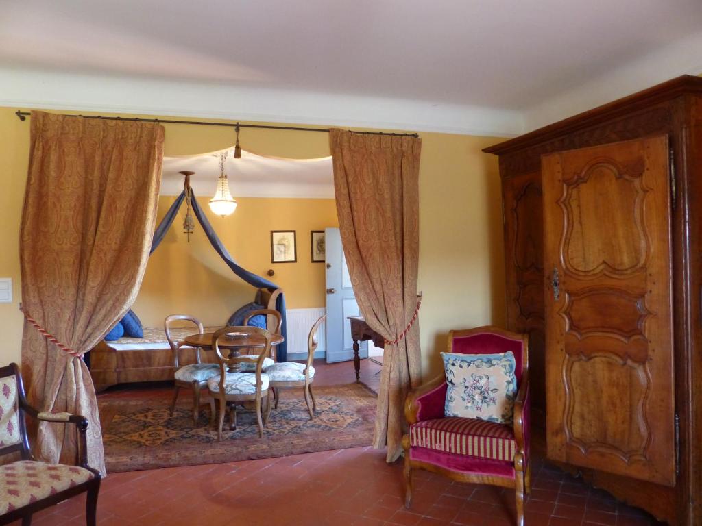 a living room with a table and a bedroom at Château du Grand Jardin in Valensole