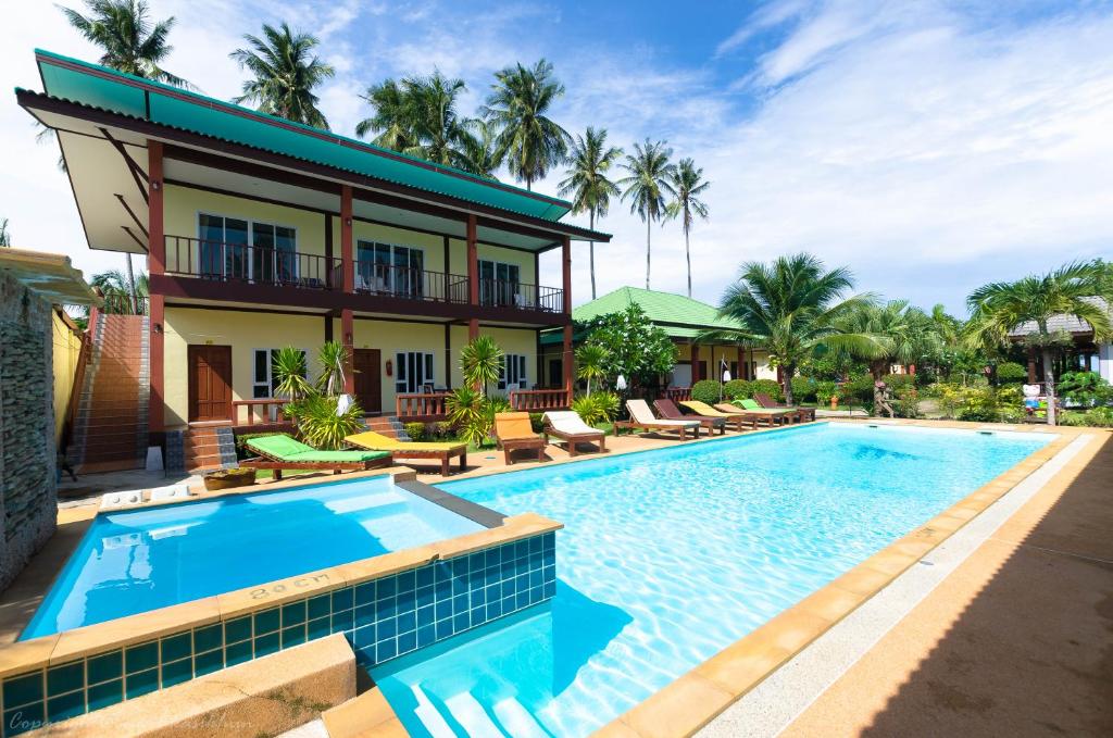 ランタ島にあるSleep In Lanta Resortの建物の前にスイミングプールがあるヴィラ