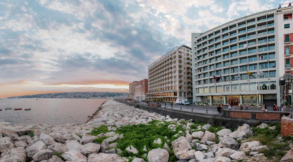 um grupo de edifícios ao lado de uma massa de água em Hotel Royal Continental em Nápoles