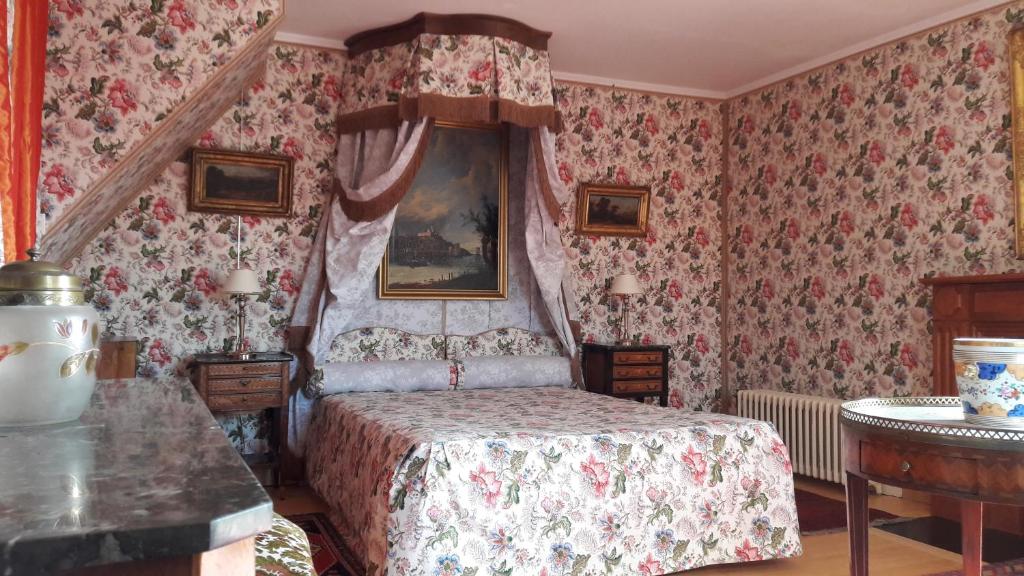 ディジョンにあるMaison d'hôtes des Perrièresの花柄の壁紙を用いたベッドルーム1室(ベッド1台付)