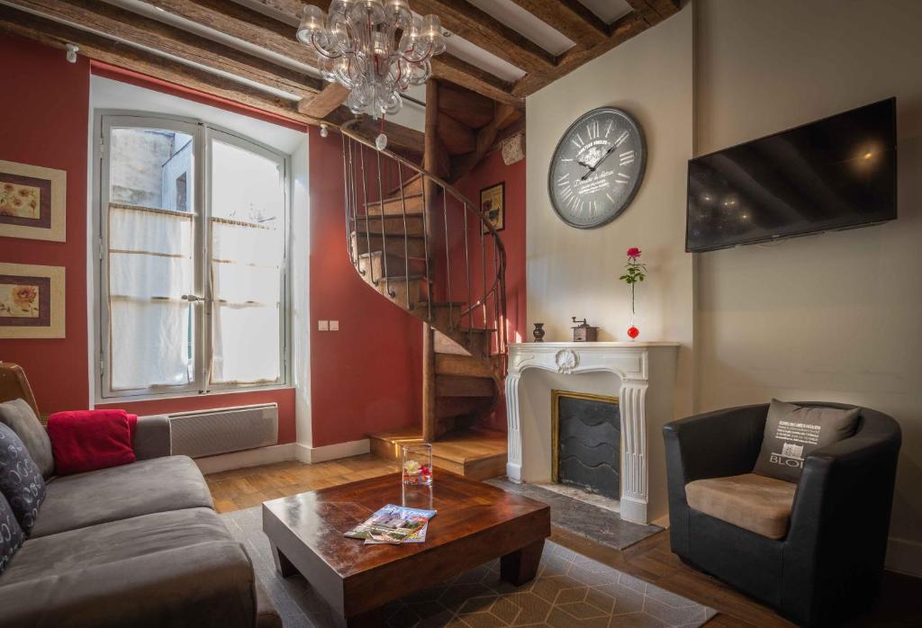 uma sala de estar com um sofá e uma lareira em Le Relais Du Petit Lion em Blois