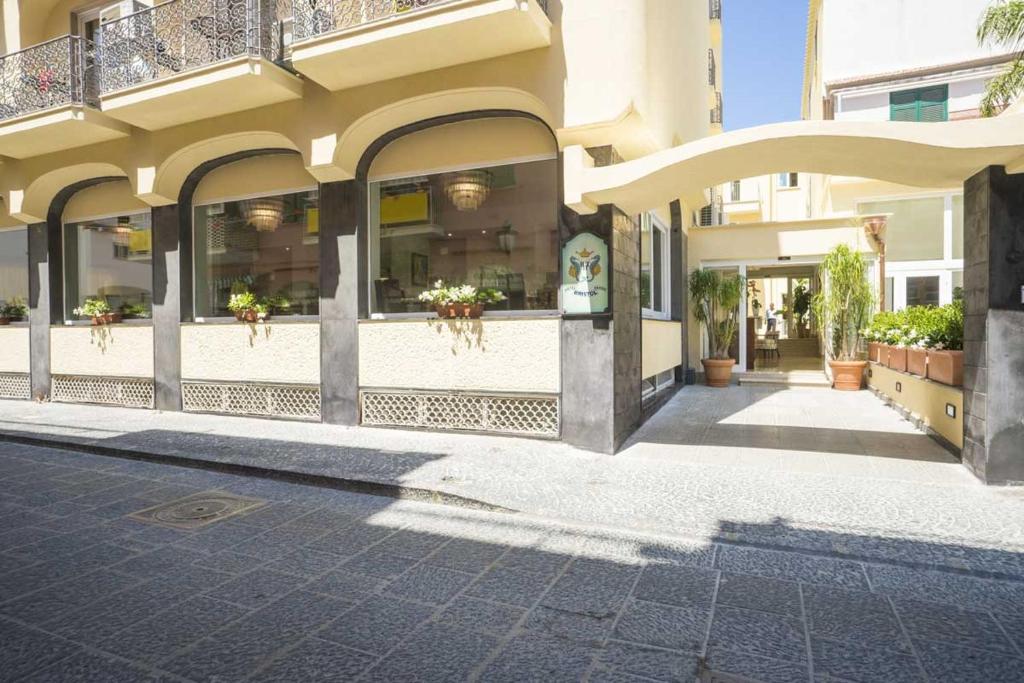 a building with a courtyard with potted plants at Casthotels Bristol Terme in Ischia