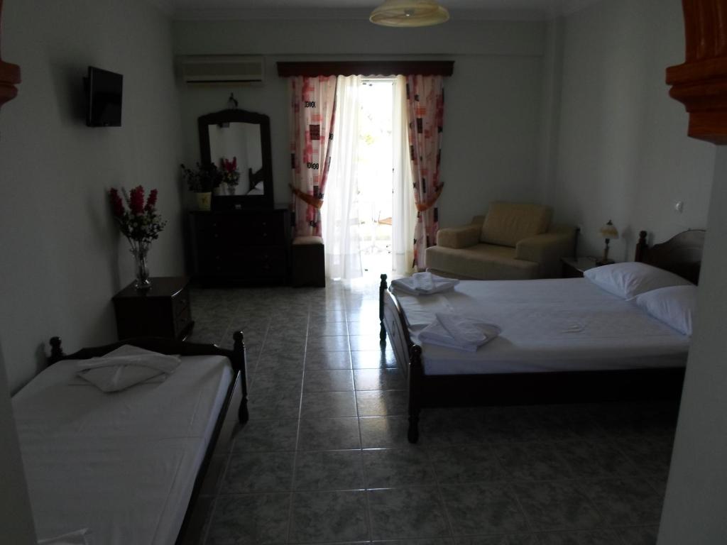 a bedroom with two beds and a living room at Hotel Villa Basil in Tsilivi