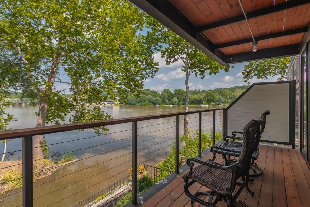 a deck with two chairs and a view of a river at Carriage House New Hope in New Hope