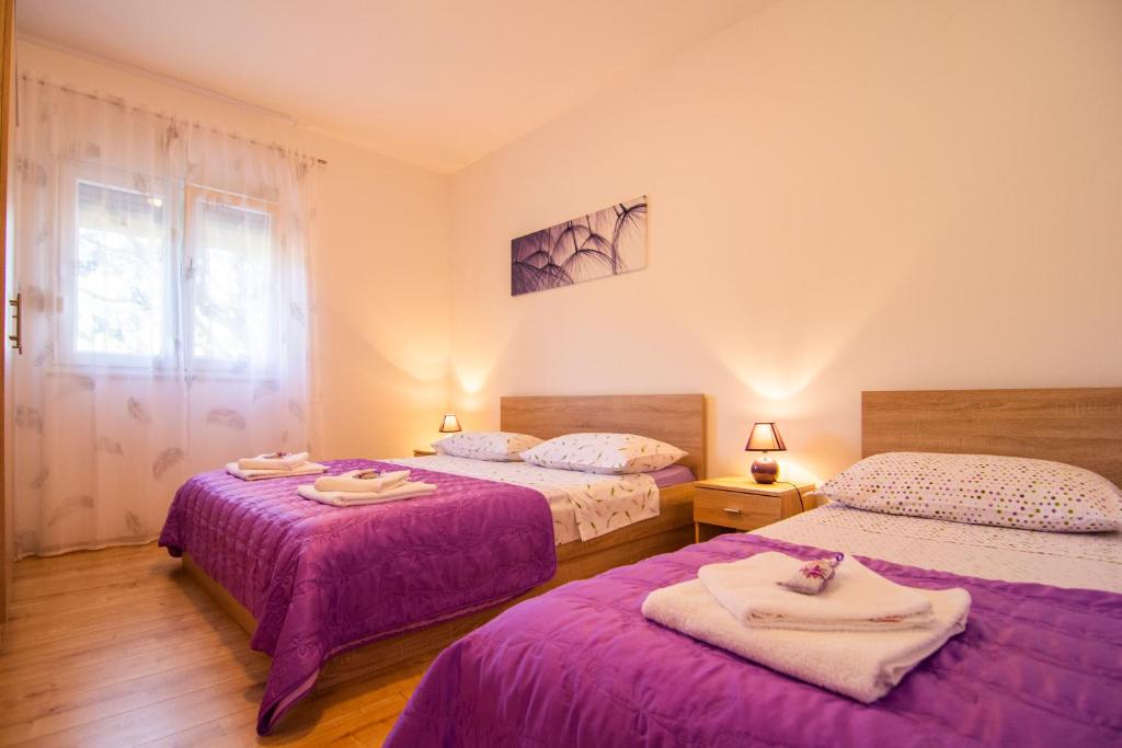 1 dormitorio con 2 camas y toallas. en Apartmani Perkovic, en Gustirna