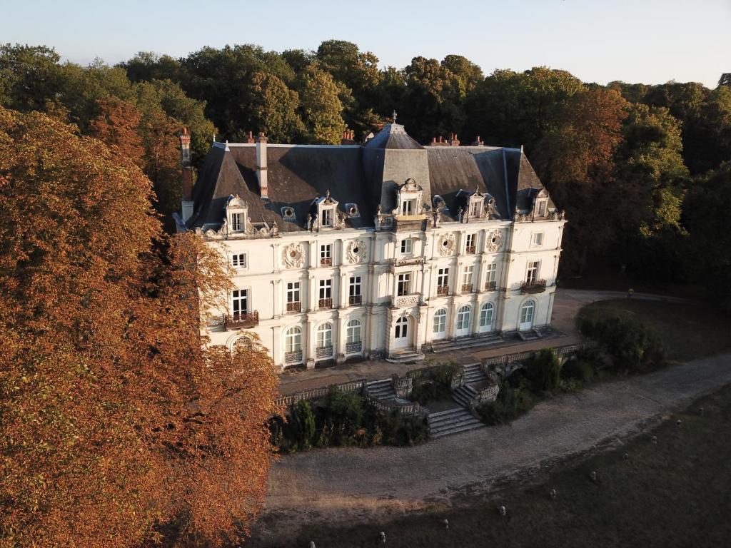 Gîte Le Haut Perché 4 pers. في Saint-Gervais-la-Forêt: بيت ابيض كبير وسط غابه