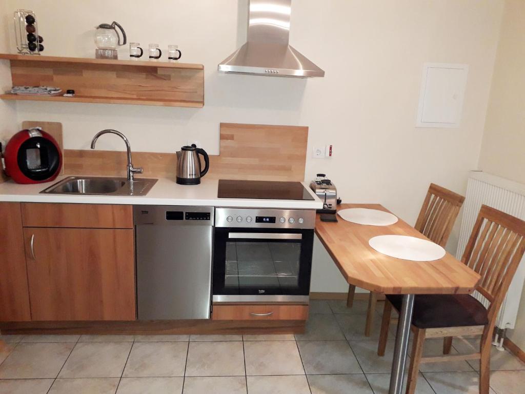 a kitchen with a sink and a stove and a table at Ferienwohnung Adams in Hinterweiler