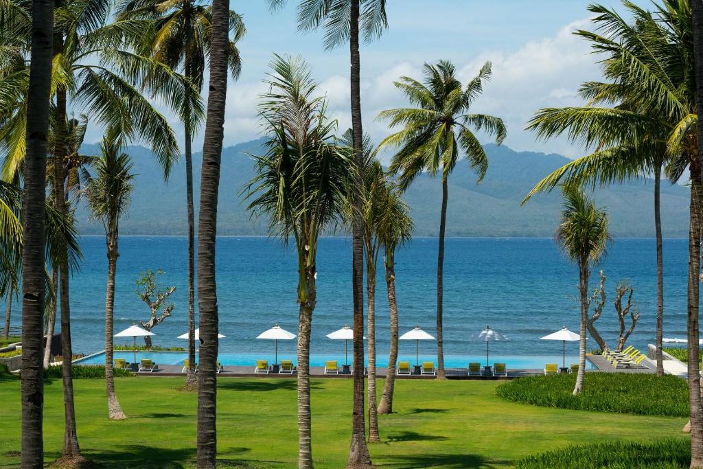 a view of the ocean from a resort with palm trees at Dialoog Banyuwangi in Banyuwangi
