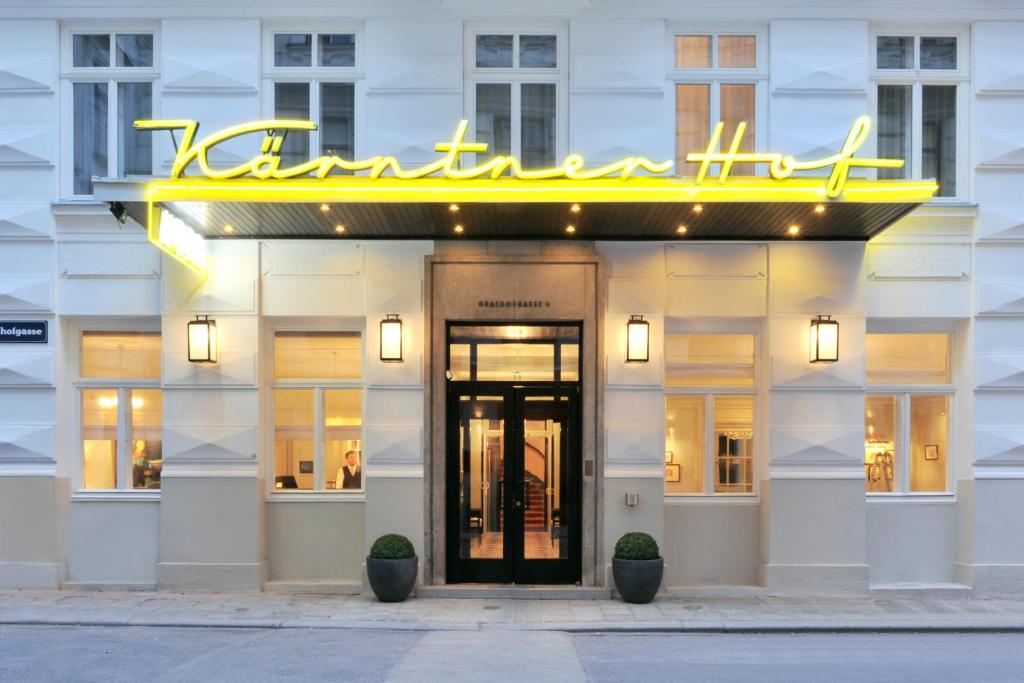 a hotel front with a neon sign over the door at Hotel Kärntnerhof in Vienna