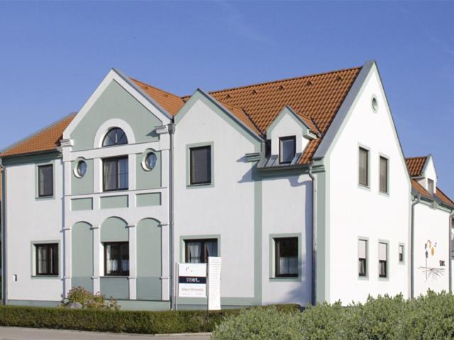 濱湖波德斯多夫的住宿－Haus Mariella，白色的大建筑,带有棕色的屋顶