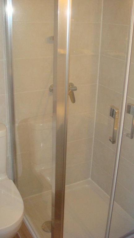 a shower with a glass door next to a toilet at Le FLORIDA in Zicavo