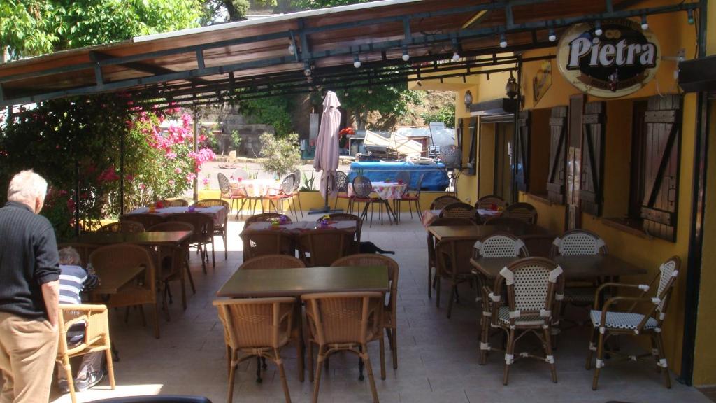 eine Gruppe von Tischen und Stühlen in einem Restaurant in der Unterkunft Le FLORIDA in Zicavo