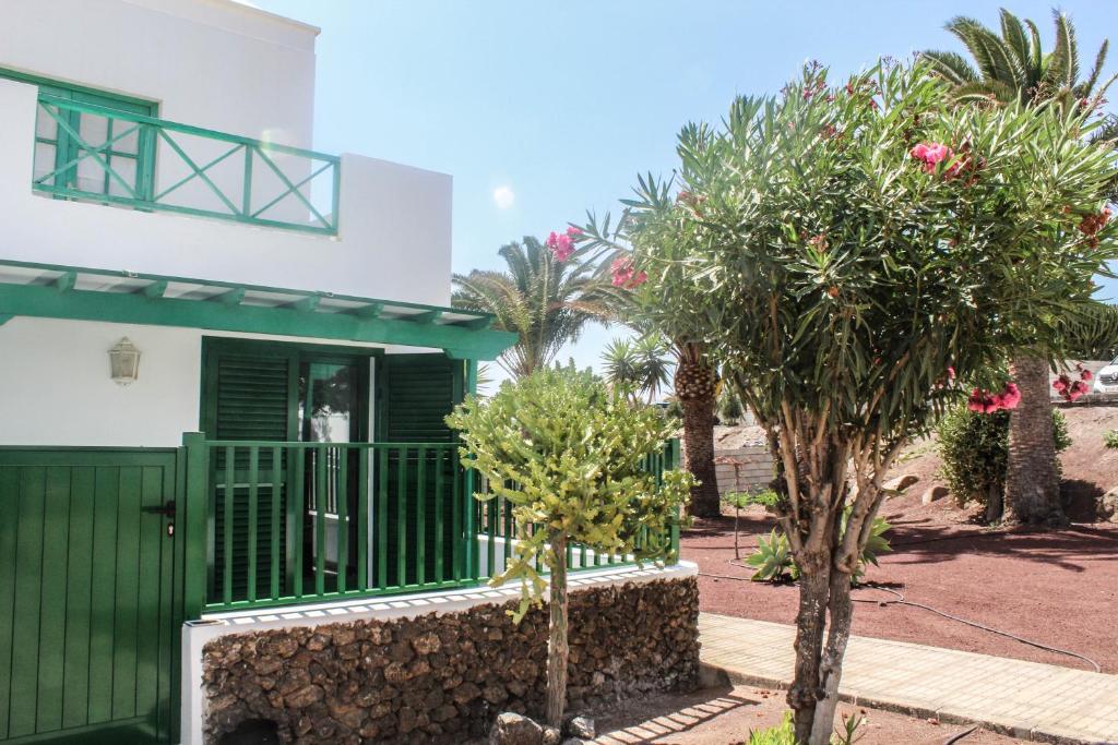 una casa con un cancello verde e alberi di fronte di Casa Real a Playa Blanca