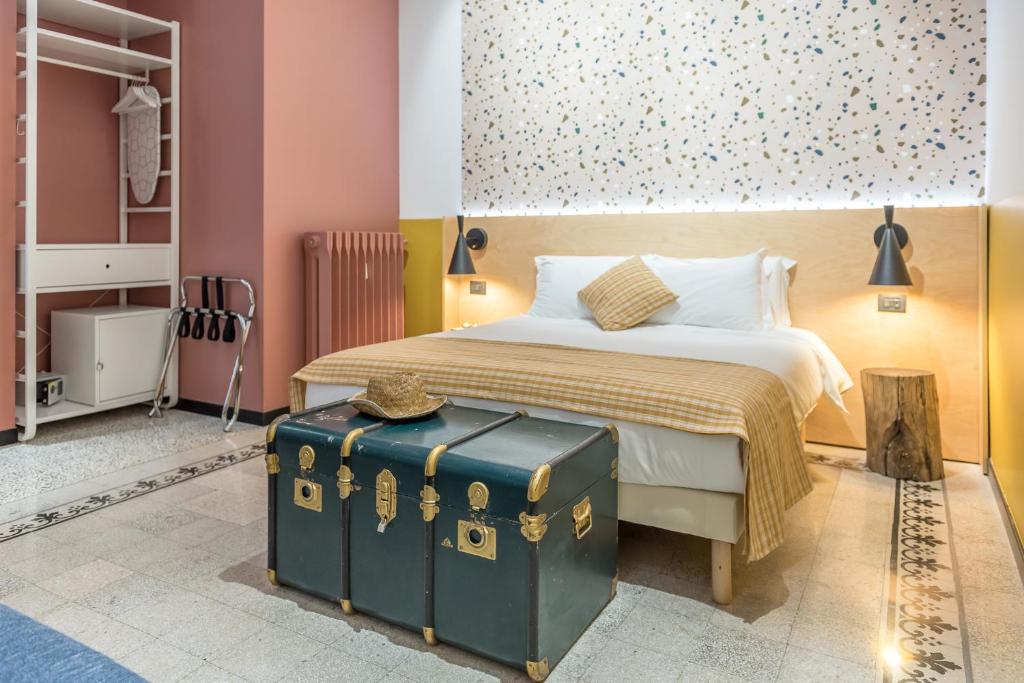 a bedroom with a bed with a green suitcase at Monocase Milano in Milan