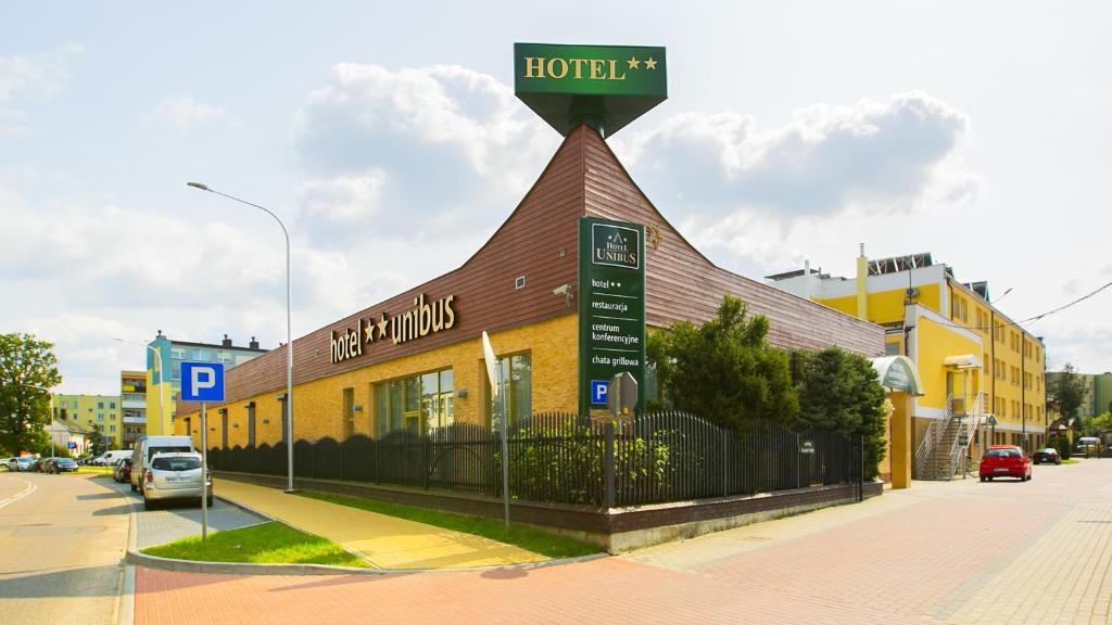 a hotel building with a sign on top of it at Hotel Unibus in Bielsk Podlaski