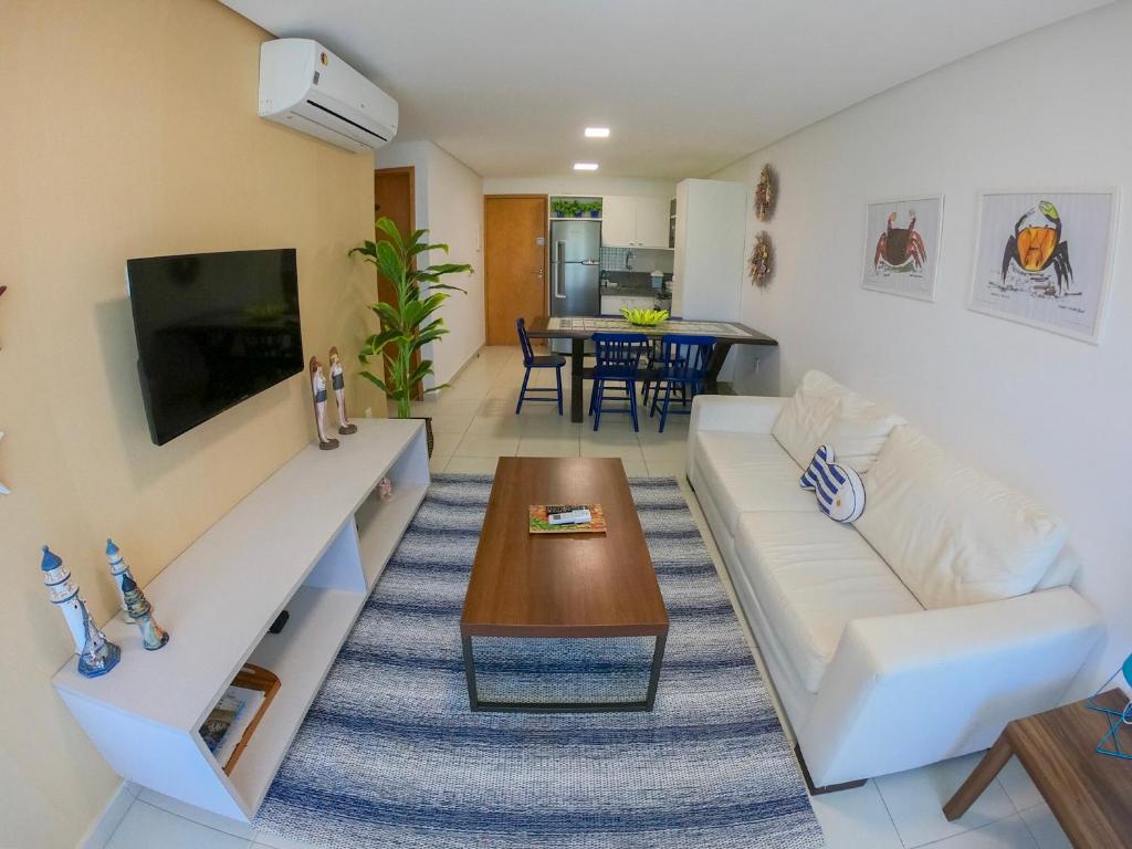 a living room with a white couch and a table at Flat Luxo Praia dos Carneiros in Praia dos Carneiros