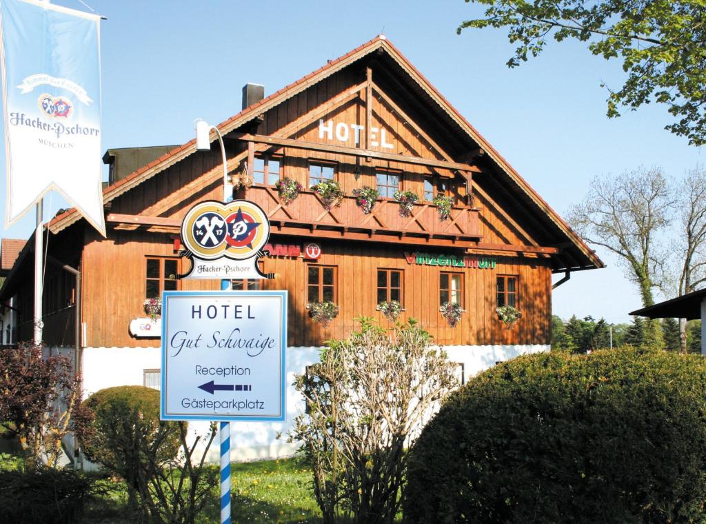 ein Hotelgebäude mit einem Schild davor in der Unterkunft Hotel Gut Schwaige in Ebenhausen