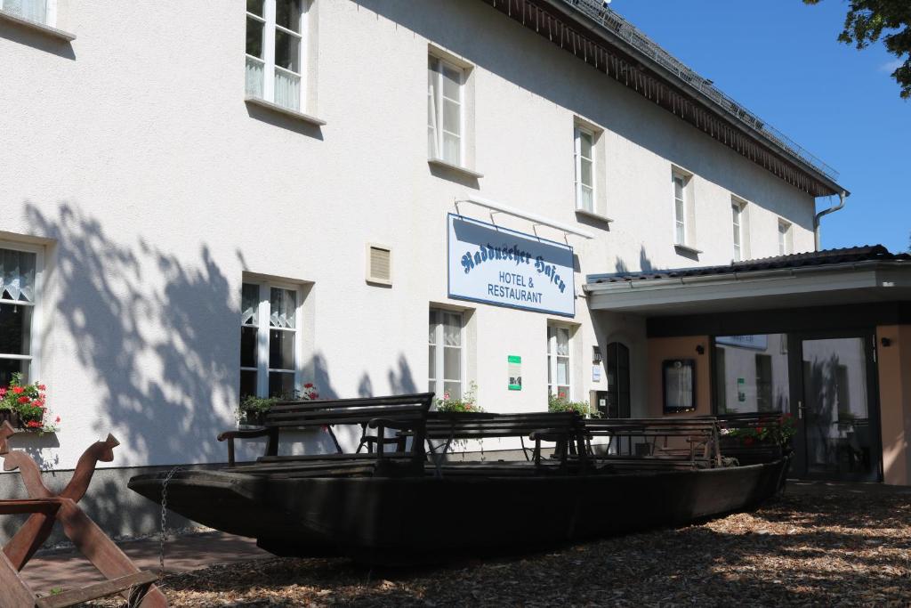 um edifício com um barco à sua frente em Radduscher Hafen em Vetschau