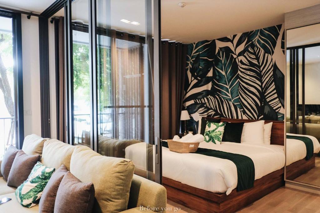 uma sala de estar com uma cama e um sofá em 23 Estate Khaoyai Tropical Style em Ban Huai Sok Noi