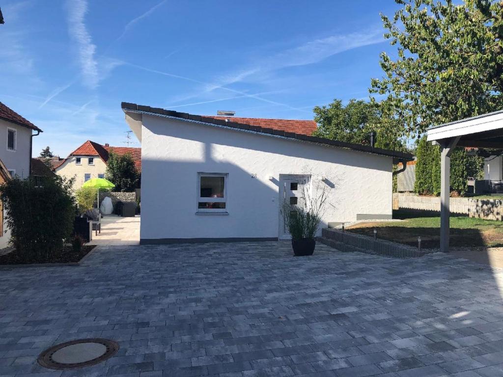 a white building with a brick driveway at Ferienhaus Köppel in Bad Staffelstein