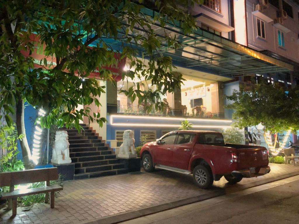un camión rojo estacionado frente a un edificio con un tren en Thành Trung Hotel, en Tuyên Quang
