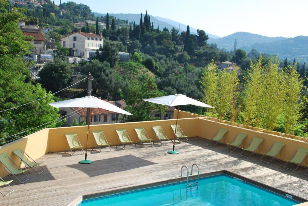 a swimming pool with chairs and umbrellas on a patio at Résidence Le Virginia by Popinns in Grasse
