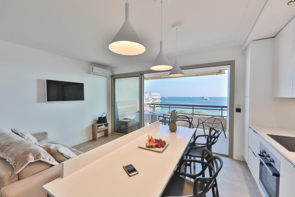 uma cozinha e sala de estar com vista para o oceano em Center Bay Luxueux appartement avec vue mer 6 eme etage em Juan-les-Pins