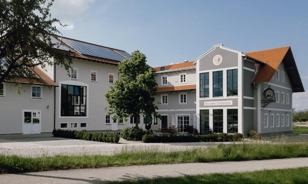 a large white building on the side of a street at Brauerei Gaststätte Stierberg in Obertaufkirchen