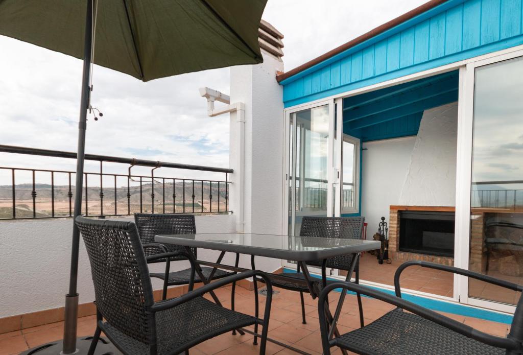 een patio met een tafel en stoelen en een parasol bij Una Casa Con Vistas En Mula in El Niño