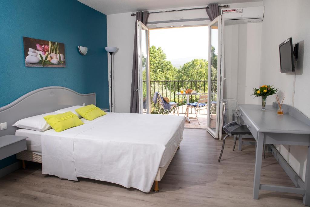 a bedroom with a bed and a balcony at Le Neoulous in Le Boulou