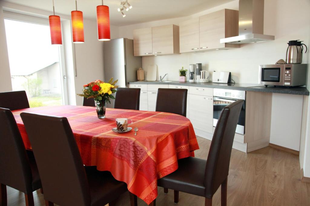 eine Küche mit einem Tisch und einer Blumenvase darauf in der Unterkunft Ferienwohnungen Stöckl in Nittendorf