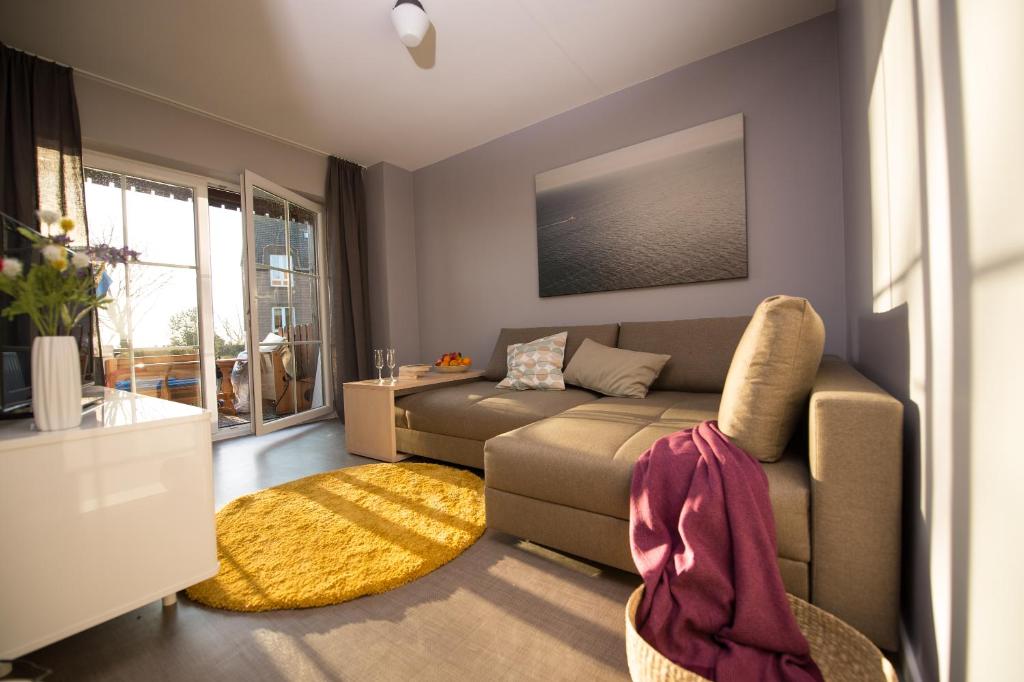 ein Wohnzimmer mit einem Sofa und einem Teppich in der Unterkunft Kleiner Sundblick – Ferienwohnung in Lemkenhafen in Fehmarn