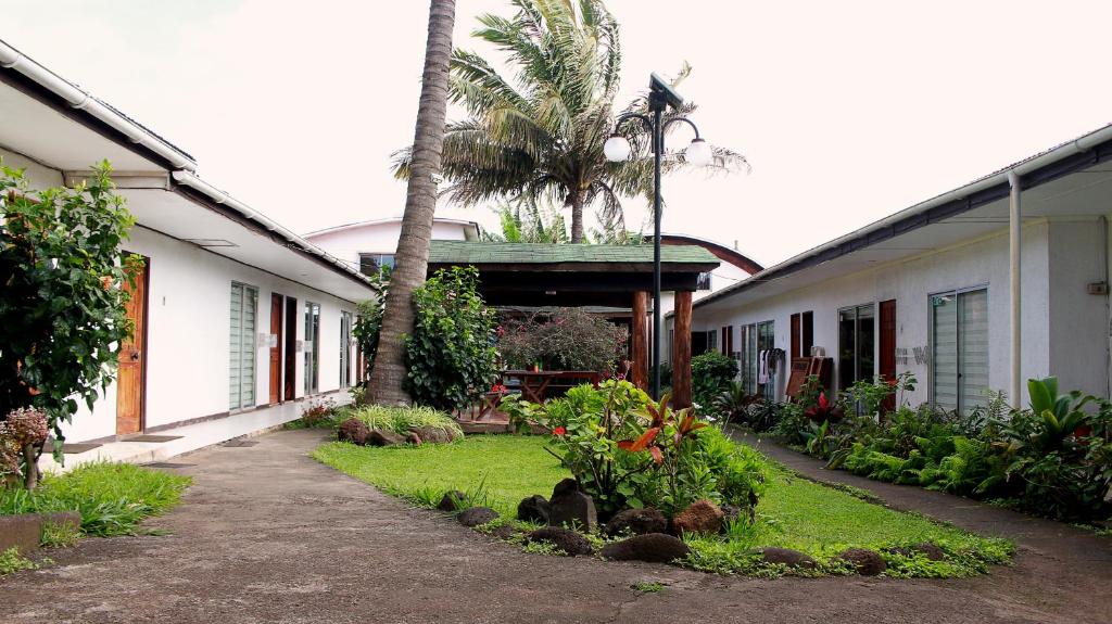 a courtyard with a palm tree and a building at Inaki Uhi Hotel in Hanga Roa