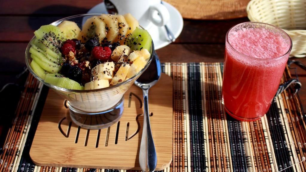 a bowl of fruit on a table with a drink at Inaki Uhi Hotel in Hanga Roa