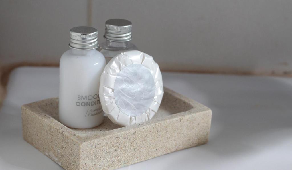 two bottles of soap and a candle on a holder at Inaki Uhi Hotel in Hanga Roa