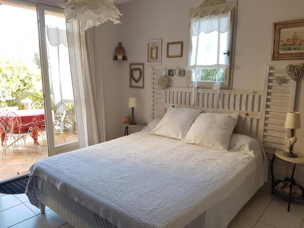 a bedroom with a bed and a patio with a table at La Parenthèse in Lauris