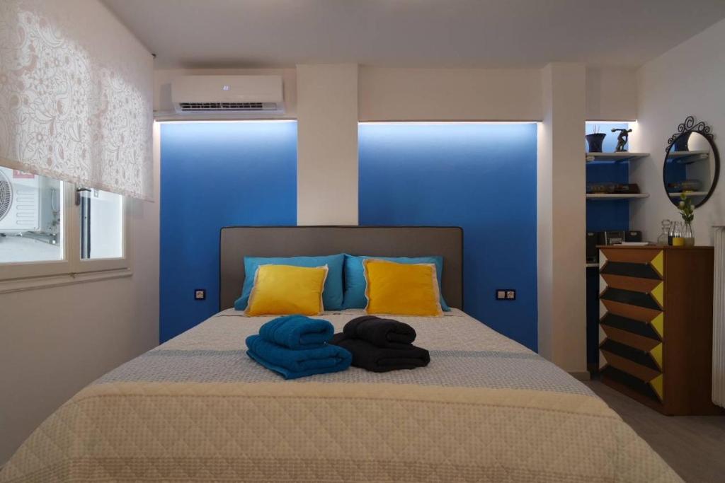 een slaapkamer met een bed met gele en blauwe kussens bij ATHENS *BLUE GRAND SUITE *DI GIORGIO CENTRAL APARTMENT in Athene
