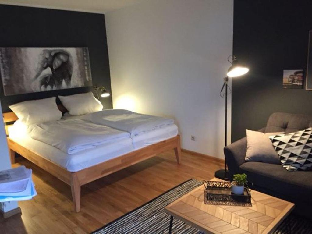 un soggiorno con letto e divano di Appartements am Park a Bad Krozingen
