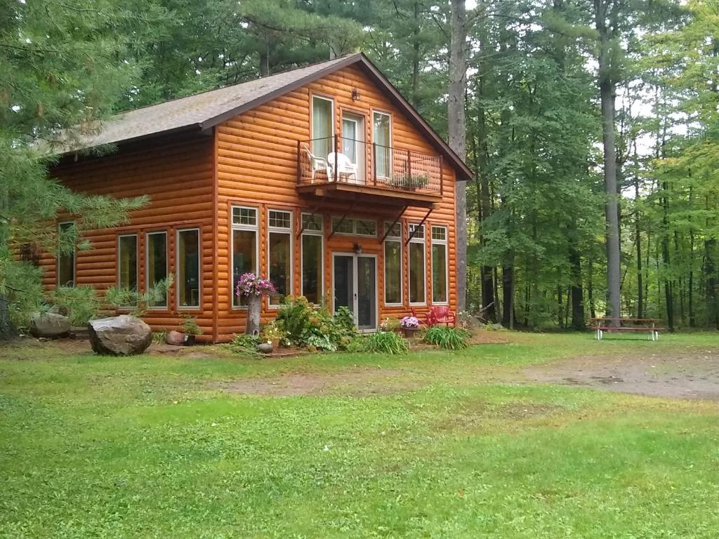 een blokhut in het bos met een balkon bij Bed and breakfast suite at the Wooded Retreat in Pine City