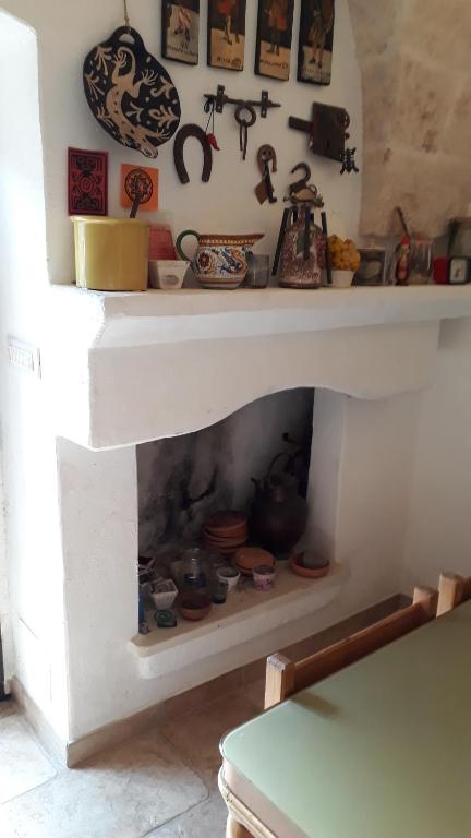 a white fireplace with pots and pans and other items at Case d'Artista in Savelletri di Fasano