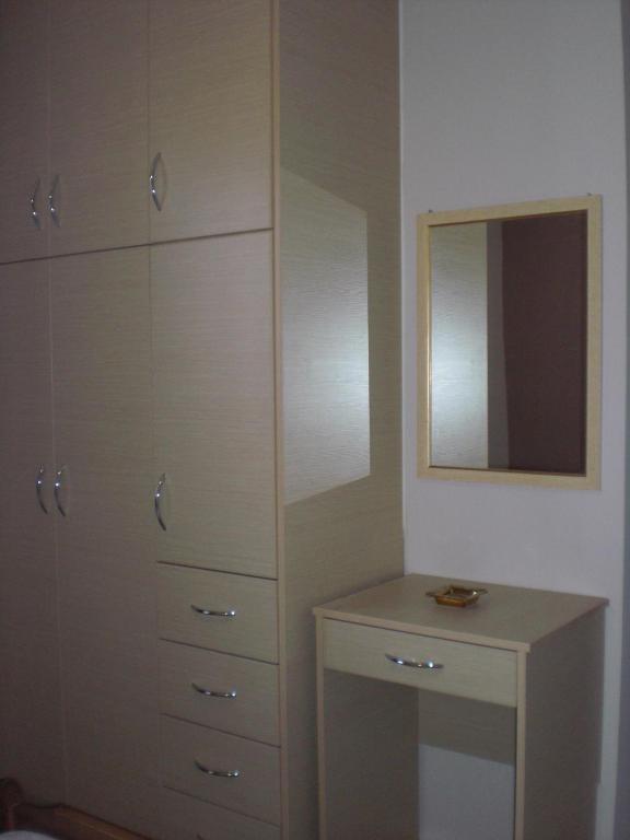 a bedroom with a dresser and a mirror at Villa Elena in Lixouri