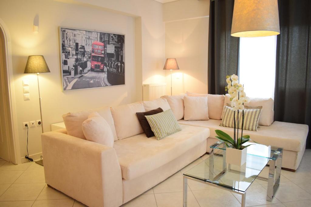 a living room with a white couch and a glass table at Luxury Apt Near The Airport in Spáta