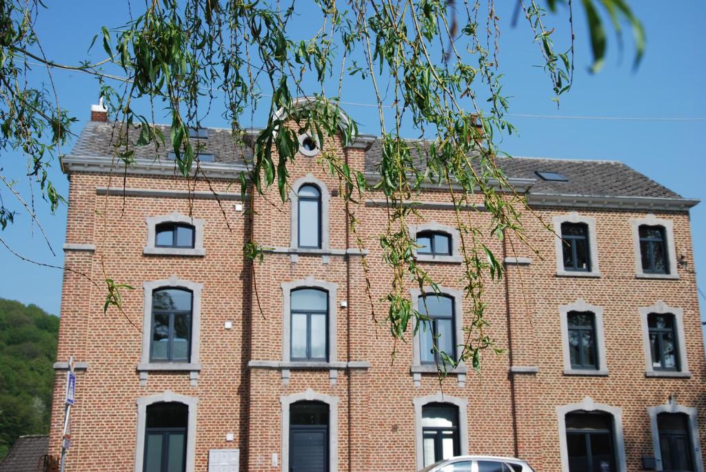 un antiguo edificio de ladrillo rojo con ventanas blancas en Logement cosy à Durbuy, en Durbuy