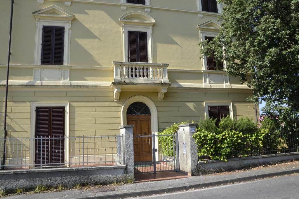 a yellow house with a balcony and a wooden door at Il Pettirosso in Monsummano Terme